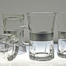 Set of 4 brushed steel banded hot beverage mugs.