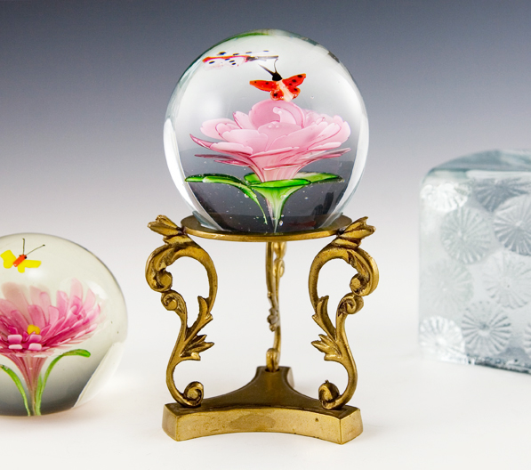 Large globe paperweight with 2 butterflies hovering over a pink mum.