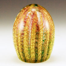 Richly laden with spiraling ribs of gold flake and mimicking wisps of green and pink verde behind the gold.