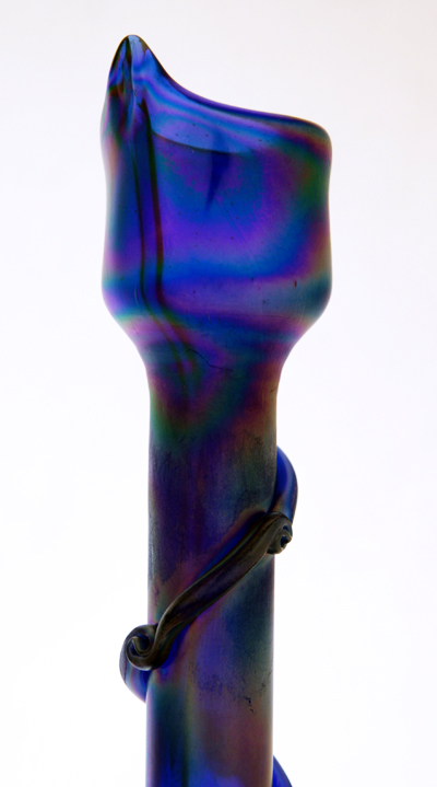Hand blown and hand decorated with pontil mark on base. It is made of cobalt blue glass and decorated with "fumed" iridescent minerals on the exterior.
