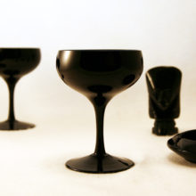 Set of 4 Mid-Century Modern opaque black blown glass saucer champagne set. This shape is usually referred to as "saucer champagne", and can be used as cocktails glasses or compotes. Beautiful, modernistic and versatile vintage glass. Color and style was popular during the mid-century Swedish Modern craze. Suspect maker is Tiffin or Duncan Miller. No maker's mark.