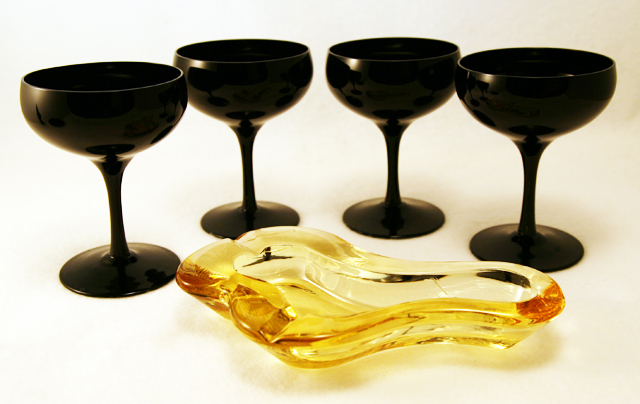 Set of 4 Mid-Century Modern opaque black blown glass saucer champagne set. This shape is usually referred to as "saucer champagne", and can be used as cocktails glasses or compotes. Beautiful, modernistic and versatile vintage glass. Color and style was popular during the mid-century Swedish Modern craze. Suspect maker is Tiffin or Duncan Miller. No maker's mark.