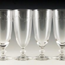 Set of four tall mid-20th century blown and cut crystal goblets. Made by Tiffin Glass from 1948 to 1967. The stylized cut wreath pattern was called 'Dolores'.