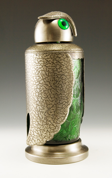The bottle body is made of detailed green glass with feathers and feet.