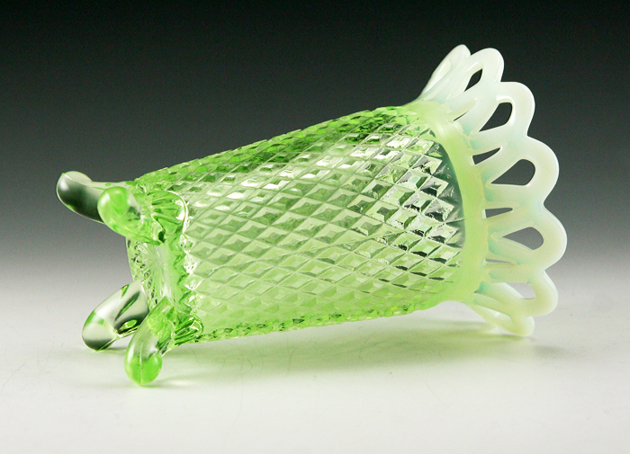 The body and feet are in light green Uranium glass and applied rim is in opaline lace.