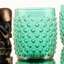 The hobnails are large and blown-out leaving indents on the interior. Made in a turquoise or light teal colored glass.