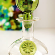 Hippie decor decanter with vertical optics, over-sized ball stopper, and sealed with a flower. Sized for vanity or liquor.
