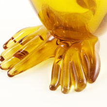 Hand-blown amber glass with applied hand-tooled face and feet.