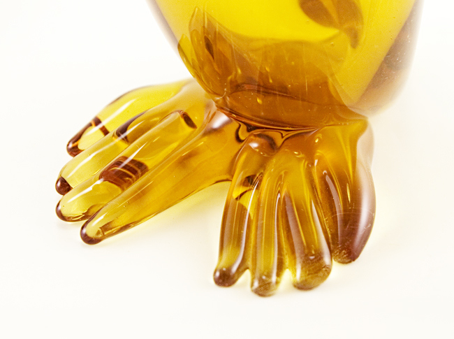 Hand-blown amber glass with applied hand-tooled face and feet.