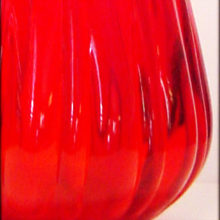 Red glass hand blown into mold then hand stretched, swung and tooled.