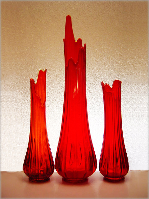 Red glass hand blown into mold then hand stretched, swung and tooled.