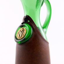 Hand blown retro Italian made grass green jug wrapped in a thick layer of trimmed leather tied closed with leather strings. Made during the 1960's through 1970's in Italy (Murano)