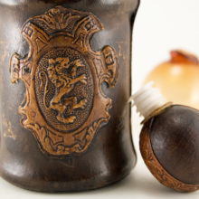 The decor on the leather is hand-worked, not machined. Some gold paint was used as accents, it is lighter than original as the paint has worn a bit over the years. Otherwise in fine original condition.
