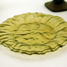 The vintage glass plates are made of heavy double layered glass. The two layers are sandwiched together, the seam can be seen nears the rims. Color is moss green, a yellowish green. Very heavy glass.