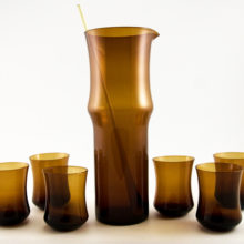 Stunning set of 1960s fine blown glassware martini set in chestnut brown. The set includes (1) decanter carafe, (1) amber glass stirrer, and (6) cocktail or juice glasses.