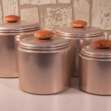 Well-preserved early 1950's Mirro aluminum canister set in light metallic pink with copper -like interior.