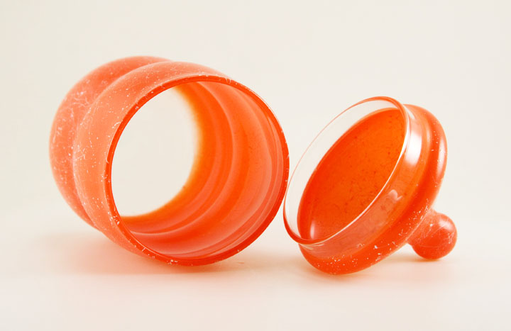 The bright orange and spatter decor was 'fired-on' over clear glass.