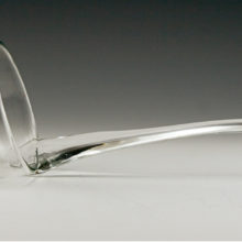The mouth of this blown glass ladle was blown in thick colorless glass with a polished flat base and applied drawn handle.