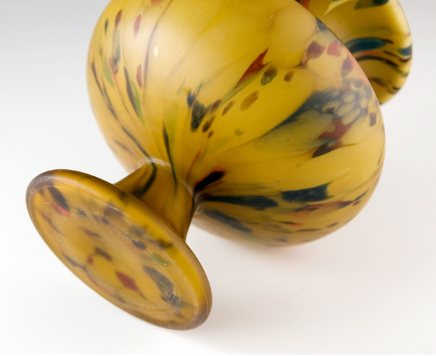 The mottled satin urn vase was removed from the blowpipe at the top, instead of the bottom, and the rim sheared off and polished. This technique removes the glass makers pontil mark.