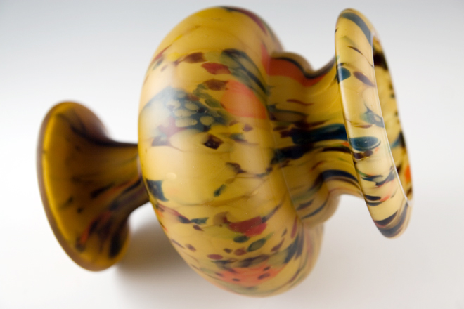 The mottled satin urn vase was hand blown in one piece from a gather of amber glass combined with layer of earthtone splatter glass.