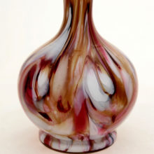 This stunning Victorian art glass vase has an inner layer of opaque white, a center layer of swirled murrine and metals with an outer layer of colorless glass. The decor method results in glass that looks like marble.