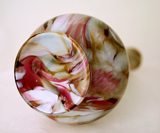 Hand-blown glass with a smooth, flattened base. The glass was cut flat and polished at the vase opening. The glass maker's punty rod held the glass at the neck. When the neck was shaved, the pontil mark was removed.