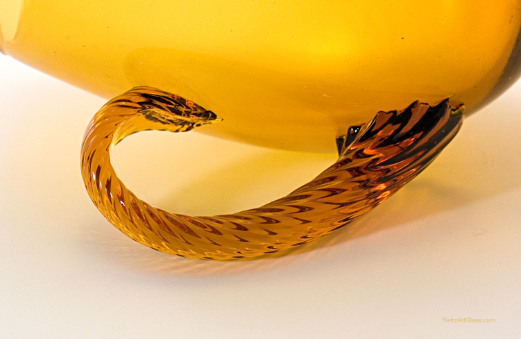 The applied handle is solid twisted glass. The dramatic wafer stem and inverted foot were formed separately and applied to the large mouth blown vessel.