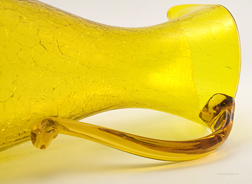 The solid glass handle was hand-pulled and applied to the crackled body.