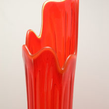 Tall retro glass floor vase. The molten glass was blown into a mold, removed and swung by the glass designer to achieve height. It was finished by hand tool to produce the stylized rim, then heat polished.