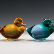 Vintage pair of Pauly & C glass resting ducks with red and white inventory label still attached.
