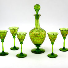Fascinating antique emerald decanter with 5 liqueur goblets. Hand-blown, hand-cut and hand-decorated with thick gold fill. The floral decor was cut into the glass and then filled with gold impasto (made with real gold).