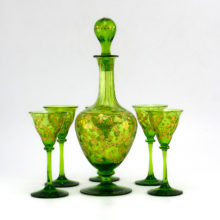 Antique emerald decanter and goblets suspected to be a French Saint Louis Cristallerie early 1900s liqueur set. The decor was first cut into the glass, then filled with gold.