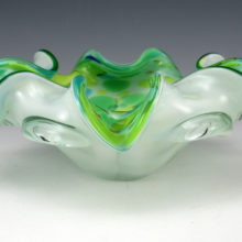 Hand-made Murano art glass cigar bowl with greens, yellows and blue colors, and copper metallic bits, cased in clear and white. Base is polished flat.