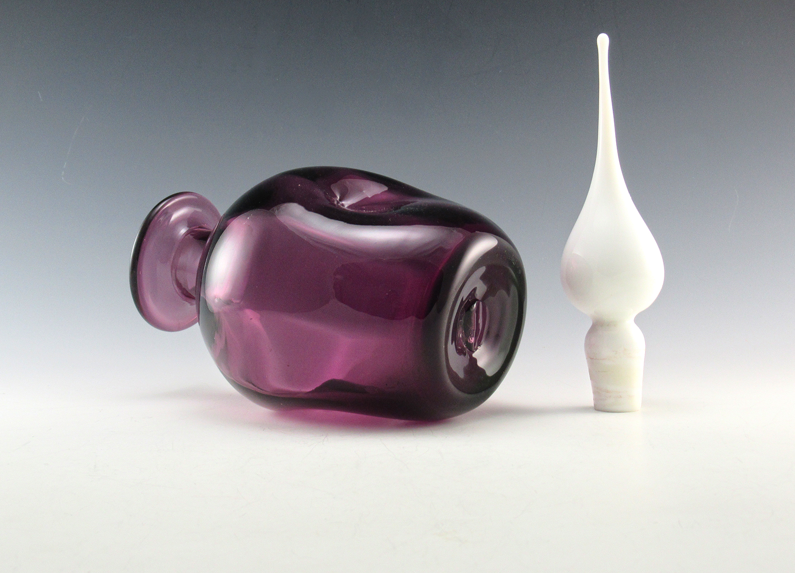 Thick walled quality vintage glass. The glass was blown into an optic mold producing the inner vertical panels. The center was pinched by hand tool. Pinched decanters offer a firm holding grip, besides looking awesome.
