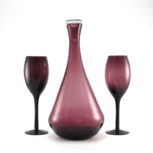Retro modern amethyst glass decanter with two color matching tall wine glasses. All were blown by hand, estimated circa mid-1960's.