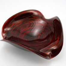 Fascinating vintage Murano glass bowl in cased black glass with red aventurine inclusions. The inclusions were swirled from the rim to the base and it glitters like fire.