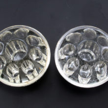These glass flower frogs were designed to sit in the base of the flower vessel or balanced upon a vase with matching opening measurements. The holes are not punched through and each individually can contain water. The center hole is for a taper candle, but can hold flower stems if you'd rather.