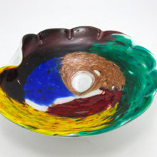 This bowl uses all the correct colors and gold aventurine of the original design but does not have the linear graphics. It is cased in white (lattimo) glass. We believe this piece may have been made by Fratelli Toso glass-works in the late 1960's to 1970's.