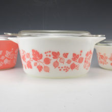 Vintage Kitchen ovenware covered casserole in Gooseberry pink on white.Mid-20th Century Pyrex Gooseberry 2 quart casserole dish #575. The pattern was designed in 1957 by Philip Johnson and produced until 1966.