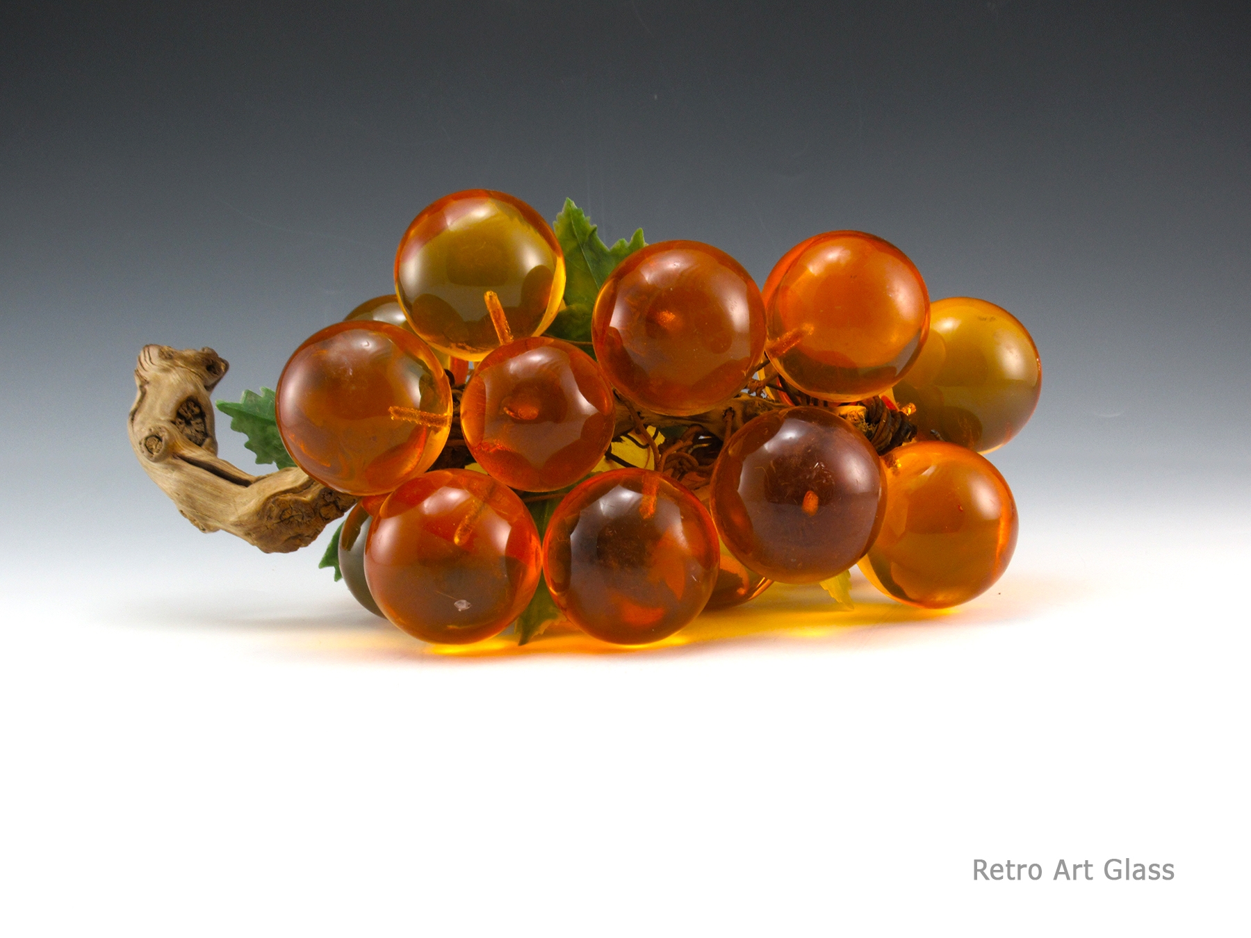 This orange resin grape log is big. It measures 14” long, 6” at widest, and 5.25” tall. Weighs 3 lbs. A must for every retro decor home!